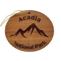 Oval ornament made out of redwood laser engraved with a mountain scene and the words Acadia National Park